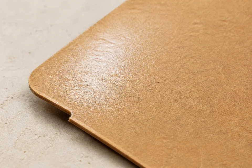 Press-applied varnish finish on packaging board