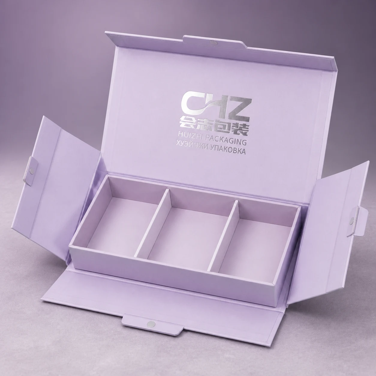 Open lavender collapsible magnetic cosmetic box with three empty compartments and unfolded side panels.