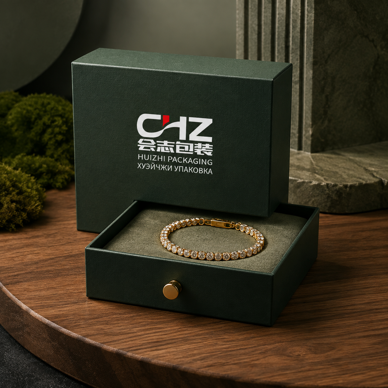 Open forest green rigid drawer box with Huizhi Packaging branding, gold pull, and bracelet on a fitted display pad.