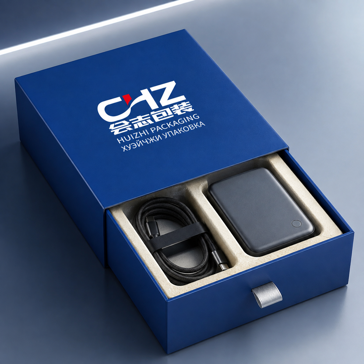 Open cobalt blue rigid drawer box with Huizhi Packaging branding, device, cable, and fitted divided insert.