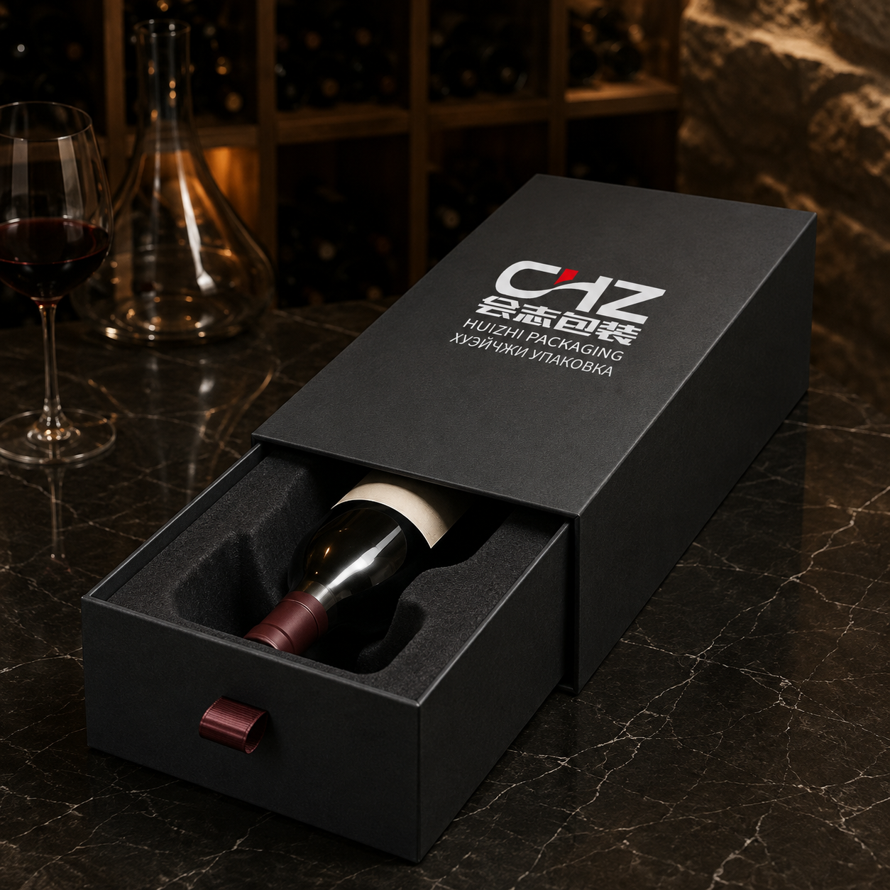 Open charcoal rigid drawer box with Huizhi Packaging branding, burgundy ribbon pull, and wine bottle in a fitted insert.