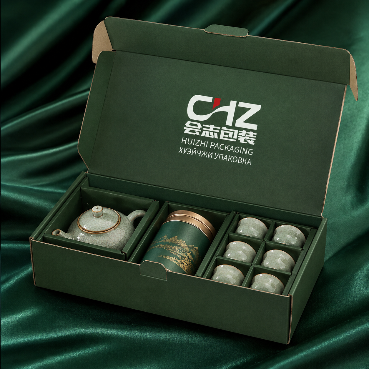 Open emerald folding gift carton with Huizhi Packaging logo holding a teapot, tea tin, and six cups in divided sections.