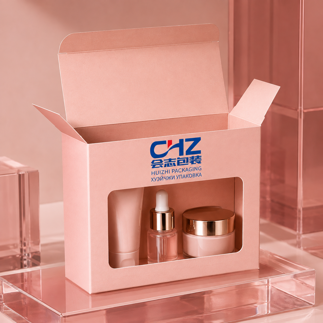 Blush pink window folding carton with Huizhi Packaging logo showing a tube, dropper bottle, and cream jar.