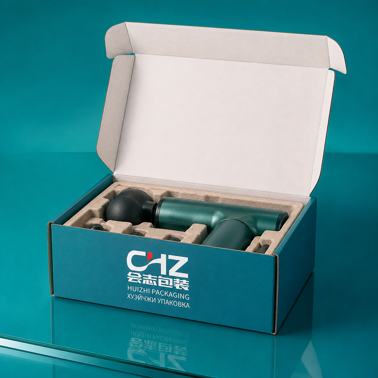 Open teal folding carton with Huizhi Packaging logo and molded-fiber insert holding a handheld device and accessories.