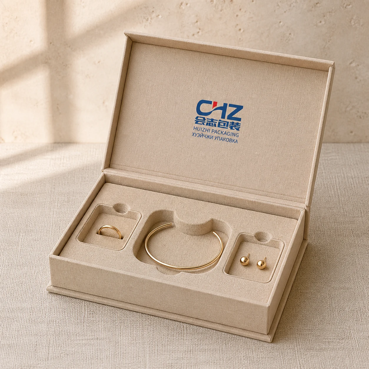 Open natural-fiber jewelry gift box with a molded-pulp insert holding a ring, bracelet, and earrings.